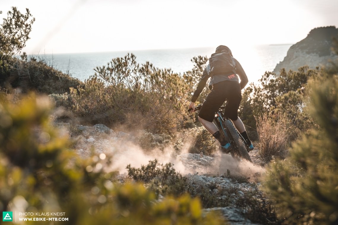  CUBE Stereo Hybrid 140 HPA 500 27.5+ action shot of a rider skidding from left to right on a dusty trail in fron of a coastal scene